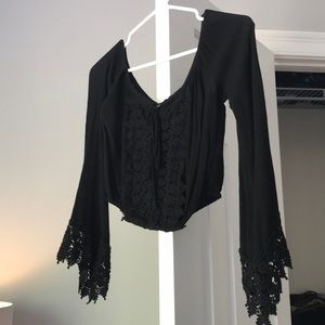 Black lace blouse wit flared long sleeves.